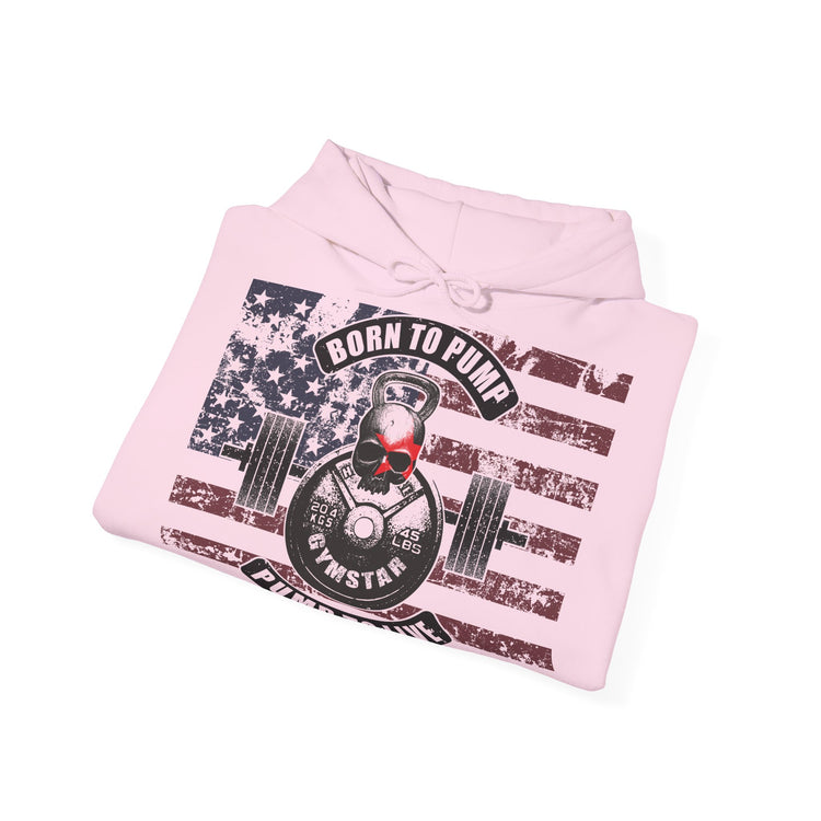 A folded light pink hoodie on a white background, featuring a distressed graphic print of an American flag with a skull wearing red sunglasses lifting a kettlebell and barbell, with the text 'BORN TO PUMP' and 'BORNSTAR'.