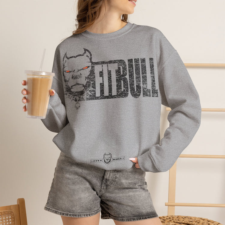 Person wearing a gray Fitbull sweatshirt with 'FitBull' logo holding a drink.