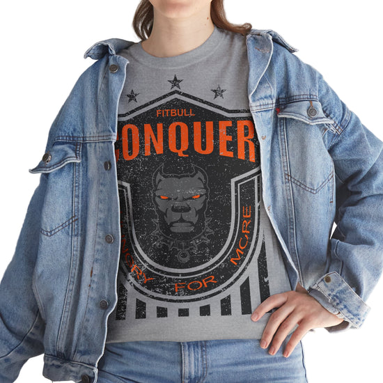 Person wearing a grayFitbull  t-shirt with a motivational Conquer graphic design and a denim jacket.