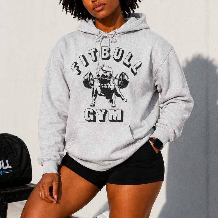 Person wearing a gray 'Fitbull Gym' hoodie with gym equipment in the background