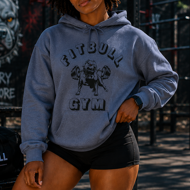 Woman wearing a Fitbull Gym hoodie and shorts outdoors.
