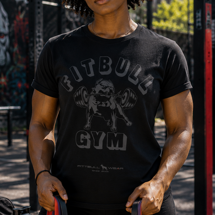 Person wearing a Fitbul Gym t-shirt holding resistance bands in an outdoor setting.
