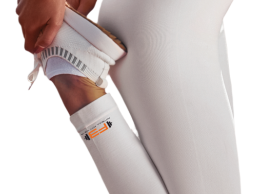 Person wearing white athletic Fitbull leggings with a black dog design and white sports bra.