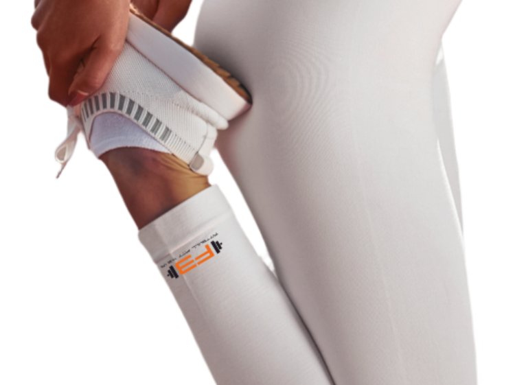 Person wearing white athletic Fitbull leggings with a black dog design and white sports bra.