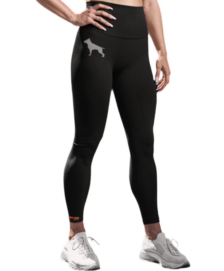 A woman with a fitness body is wearing sports leggings and a black Fitbull sports bra branded with the Fitbull gym logo.