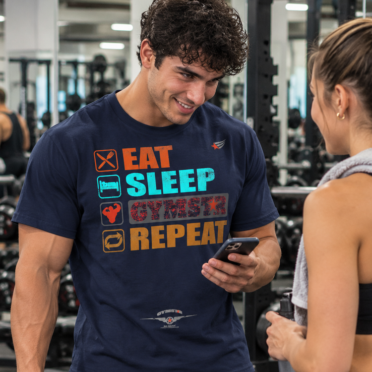 Luca Moretti wearing a navy blue GYMSTAR Eat Sleep Repeat graphic T-shirt, smiling while holding a smartphone and workout towel during a conversation with a woman at the gym.