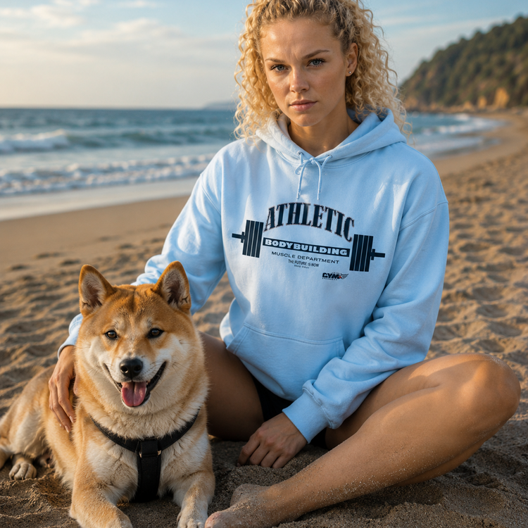 Woman in a light blue Gymstar hoodie with a dog on a beach