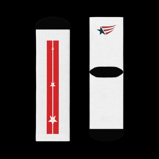 A pair of white crew training socks with red and blue accents and a star pattern on the side seams, displayed on a person's legs against a black. Top and bottom view.
