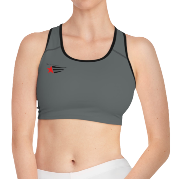 A women's solid grey athletic sports bra Gymsatr. It features black trim around the neckline and armholes. A logo with a red star and three black stripes is on the left side of the chest, with the text "GO HEAVY" above it.