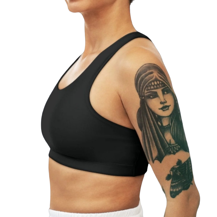 A woman wearing Black  sports, fitness bra from the Gimstar brand, with white seams and a small logo on the left side. Left side view.
