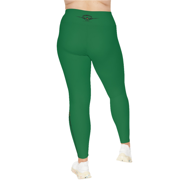 A woman wearing green high-waisted fitness leggings Gymstar with a logo on the waistband, paired with white sneakers. Rear view.