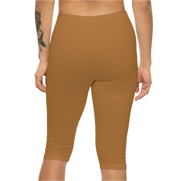 A woman wearing pair of brown Gymstar fitness leggings with a small logo on the left thigh area, designed for women. Rear, close up view.
