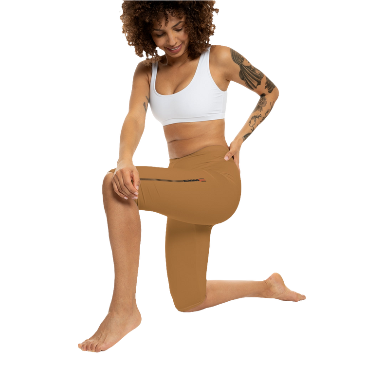 A woman wearing pair of brown Gymstar fitness leggings with a small logo on the left thigh area, designed for women. Front action  view.