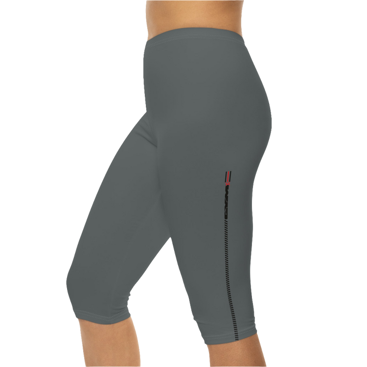 A woman wearing pair of gray Gymstar brand fitness leggings featuring a mid-rise waist and a logo, designed for yoga and other workouts. Left side close up view.