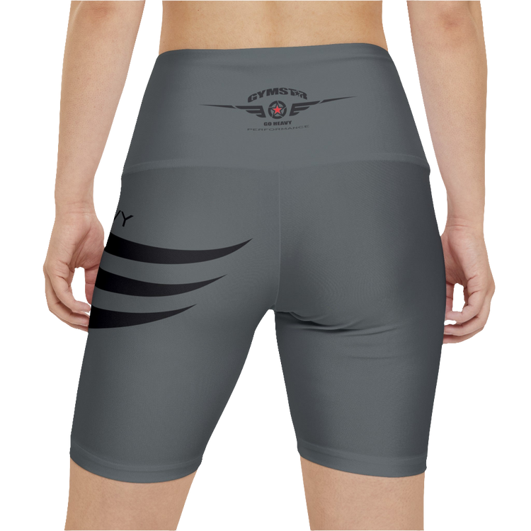 A woman wearings pair of green fitness leggings with a red star and 'GYMSTAR' logo on the upper left leg, waistband, and a 'GO HEAVY' text on the right side of the waistband. Rear close up view.