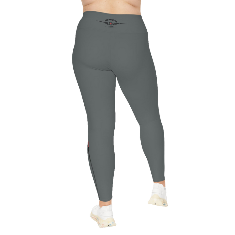 A woman wearing pair of grey high-waisted Gymstar fitness leggings with a logo on the upper left thigh, paired with white sneakers. Rear view.