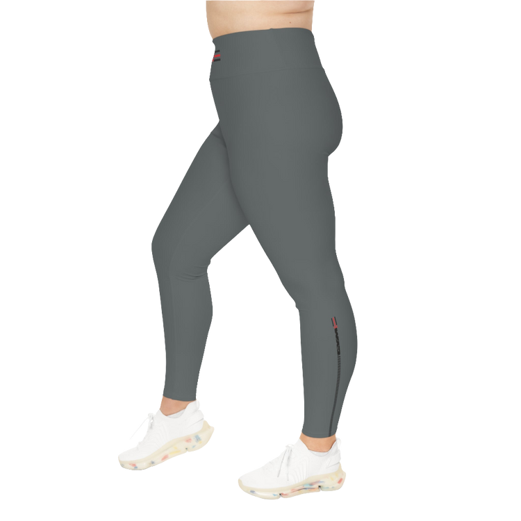 A woman wearing pair of grey high-waisted Gymstar fitness leggings with a logo on the upper left thigh, paired with white sneakers. Right side view.