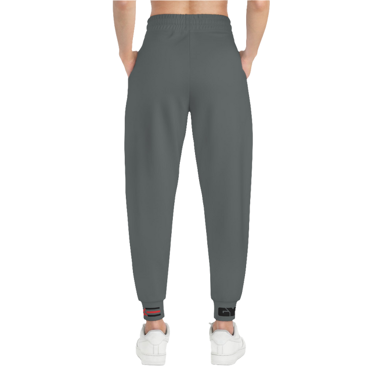 A person standing frontal, wearing silver gray joggers Gymstar with a logoand white sneakers. The joggers have a ribbed bottom and waistband cuffs, and feature two side pockets.