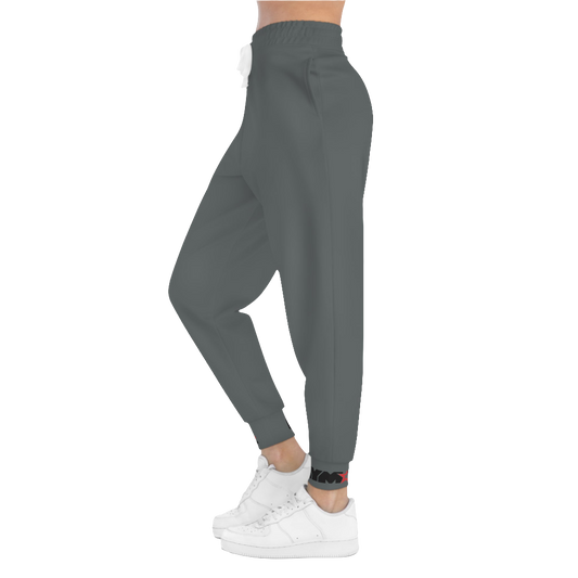 A person standing frontal, wearing silver gray joggers Gymstar with a logoand white sneakers. The joggers have a ribbed bottom and waistband cuffs, and feature two side pockets.