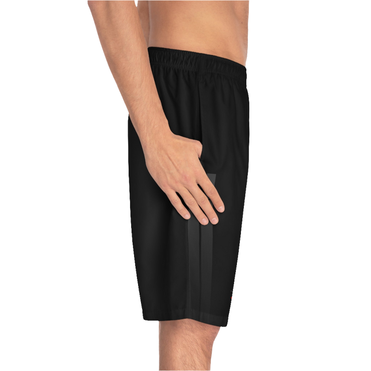A man wearing black sports shorts with an elastic waistband and drawstrings, featuring a logo on the left leg  left side view.