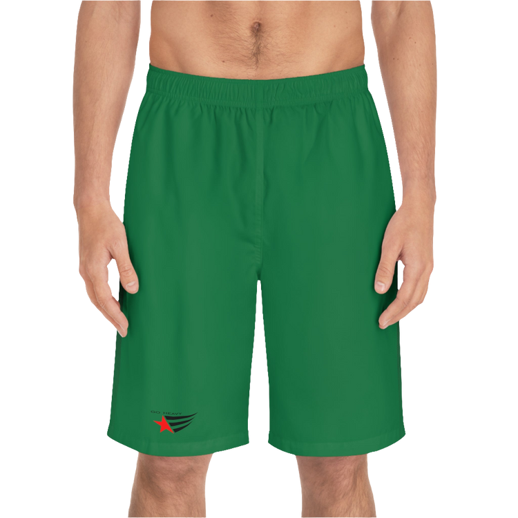 A man wearing pair of green men's board shorts with a small Gymstar logo on the left leg front side view.