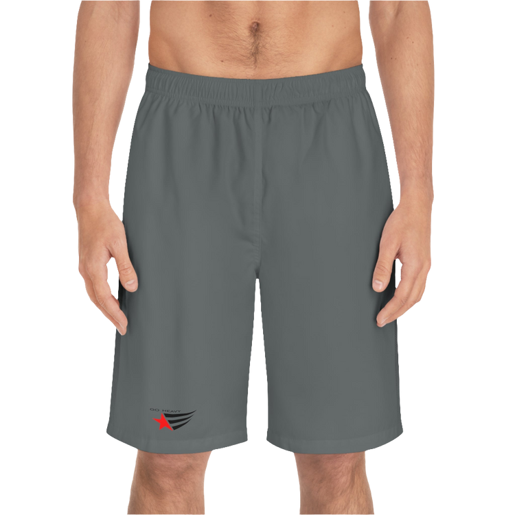 A man wearing grey sports shorts with an elastic waistband and drawstrings, featuring a logo on the left leg  front side view.