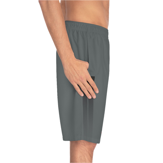 A man wearing grey sports shorts with an elastic waistband and drawstrings, featuring a logo on the left leg  left side view.