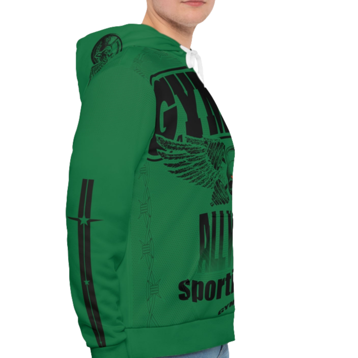 A man wearing a green hoodie with 'GYMSRTA' and related graphics printed on the front, including a star and the text 'ALL WINNERS'. He has a casual and confident expression right cide view.