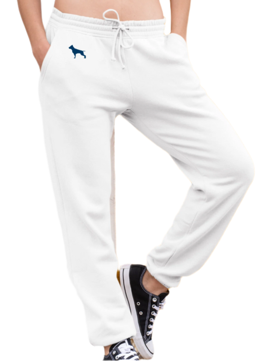Eine Frau trägt weisse Fitbull-Jogginghosen mit dem Logo der Marke und ein sportliches weisse Tanktop.