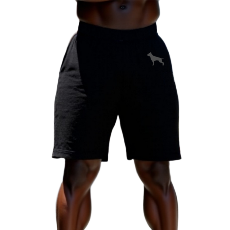 A part of the body of a muscular man shows us black sports shorts of the sportswear brand Fitbull, with the company's logo.