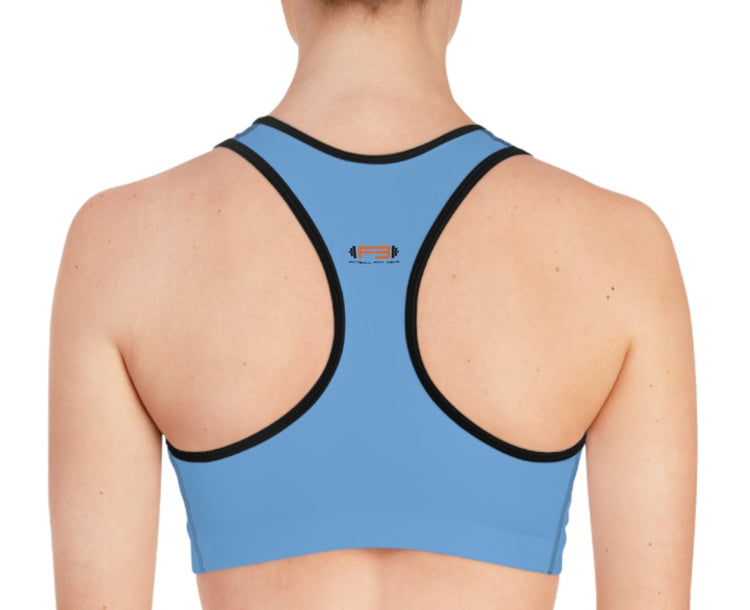 Eine Frau in einem blau Sport-BH und Fitbull-Jogginghosen posiert für ein Foto  Rückansicht