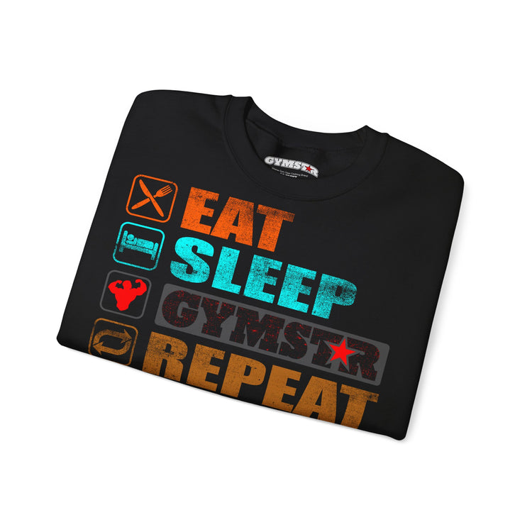 A black crewneck t-shirt with a colorful graphic print reading 'EAT SLEEP GYMSTAR REPEAT' alongside fitness-themed icons, shown folded on a white background.