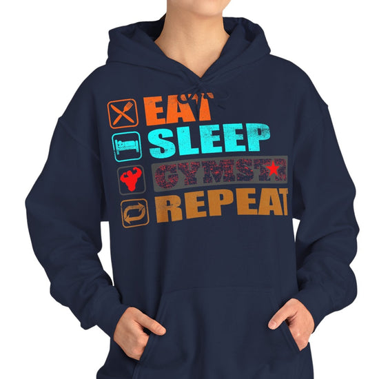 A woman modeling a navy blue hoodie with a colorful graphic on the chest that reads 'EAT SLEEP CYMSTAR REPEAT' with small icons next to each word, against a plain white background.