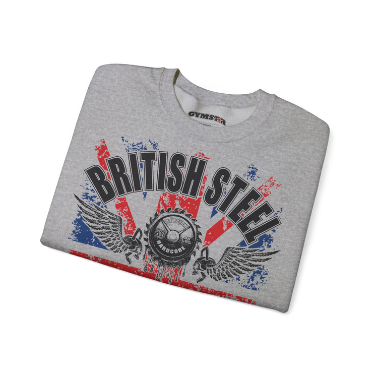 A folded heather gray crewneck sweatshirt featuring a distressed graphic print with the words 'BRITISH STEEL' in black, red, and blue, along with wings and a central circular emblem. The inner collar shows the brand name 'GYMMASTER'.