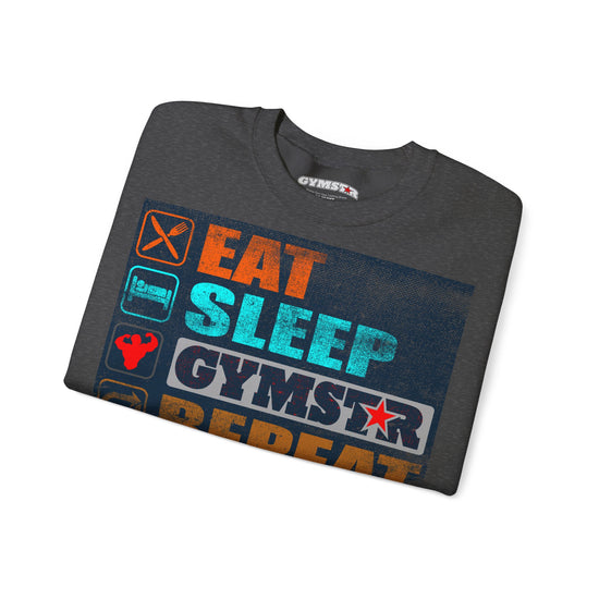 A dark gray heather t-shirt with a colorful graphic print that reads 'EAT SLEEP GYMSTAR REPEAT' in orange, teal, and white, with gym-themed icons on the front. The brand name 'GYMSTAR' is visible on the inner neck label.