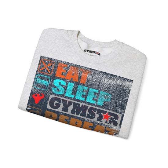 A folded light heather gray t-shirt with a distressed graphic print on the front reading 'EAT SLEEP GYMSTAR' in orange, teal, and white, with a small GYMSTAR logo printed inside the collar.