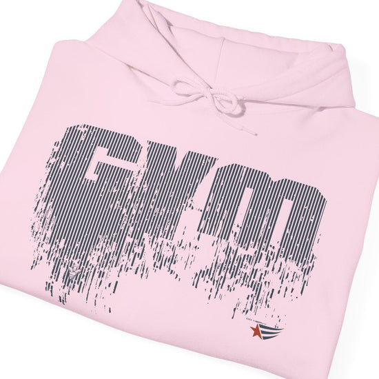 A light pink folded hoodie with a distressed black 'GYM' graphic on the front, a drawstring hood, and a small logo near the lower right hem, shown on a plain white background.