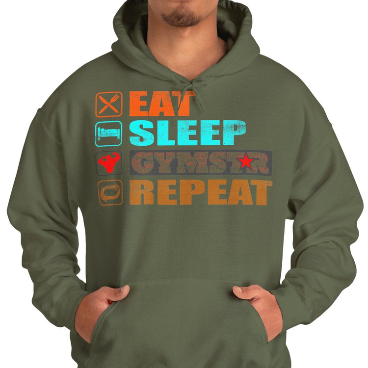 A man wearing an olive green hoodie with a colorful graphic print that reads 'EAT SLEEP GYMSTAR REPEAT' with corresponding icons, paired with blue jeans, against a plain white background.