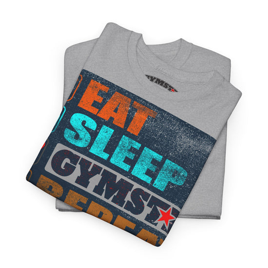 A folded heather gray t-shirt with a colorful graphic print reading 'EAT SLEEP GYMST' in orange, teal, and dark blue text over a distressed dark blue background, on a white studio background.