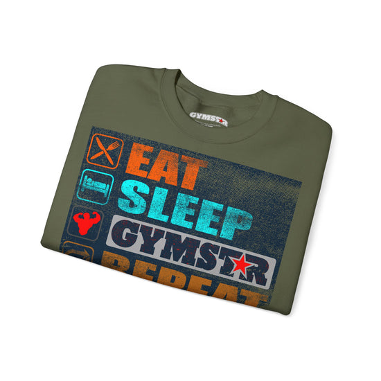 An olive green t-shirt with a colorful graphic print reading 'EAT SLEEP GYMSTAR REPEAT' in orange, blue, and white, shown on a plain white background.