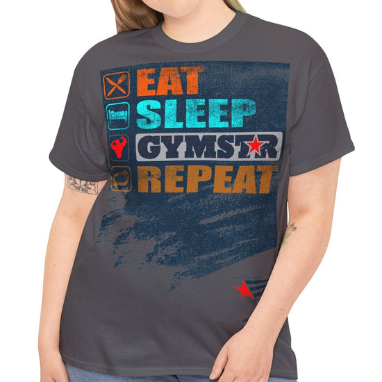 A woman modeling a dark gray graphic t-shirt with the words 'EAT SLEEP GYMSTAR REPEAT' in colorful block letters over a distressed blue background, paired with blue jeans against a plain white studio background.