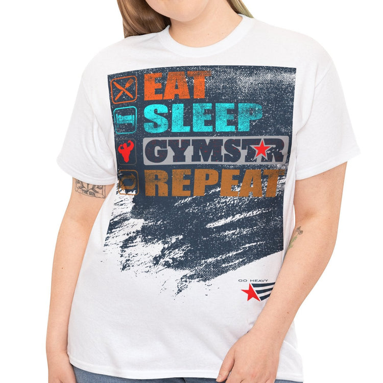 A woman modeling a white graphic t-shirt with a distressed design that reads 'EAT SLEEP GYMSTAR REPEAT' in colorful block letters over a dark blue paint-splatter background, paired with blue jeans against a plain white studio background.