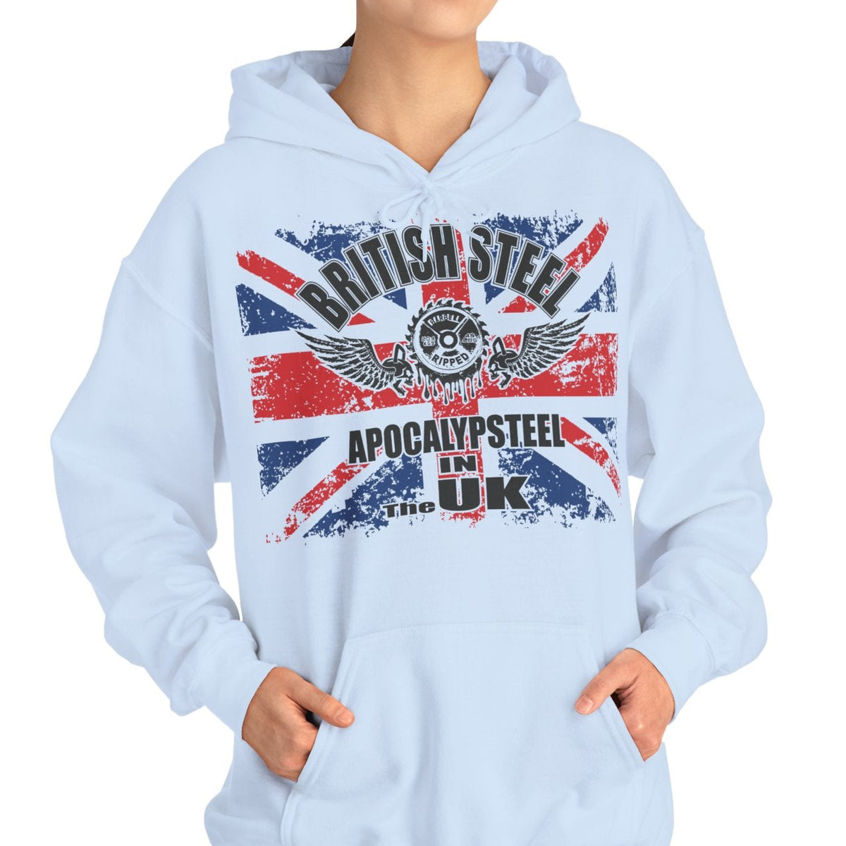 A woman modeling a light blue hoodie with a distressed Union Jack graphic and the text 'BRITISH STEEL' and 'APOCALYPSE STEEL IN THE UK' on the front, set against a plain white background.