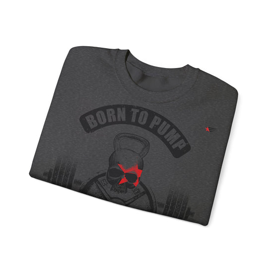 A dark heather gray folded t-shirt featuring a graphic of a skull wearing sunglasses with a red star accent, under a black arch that reads 'BORN TO PUMP'.