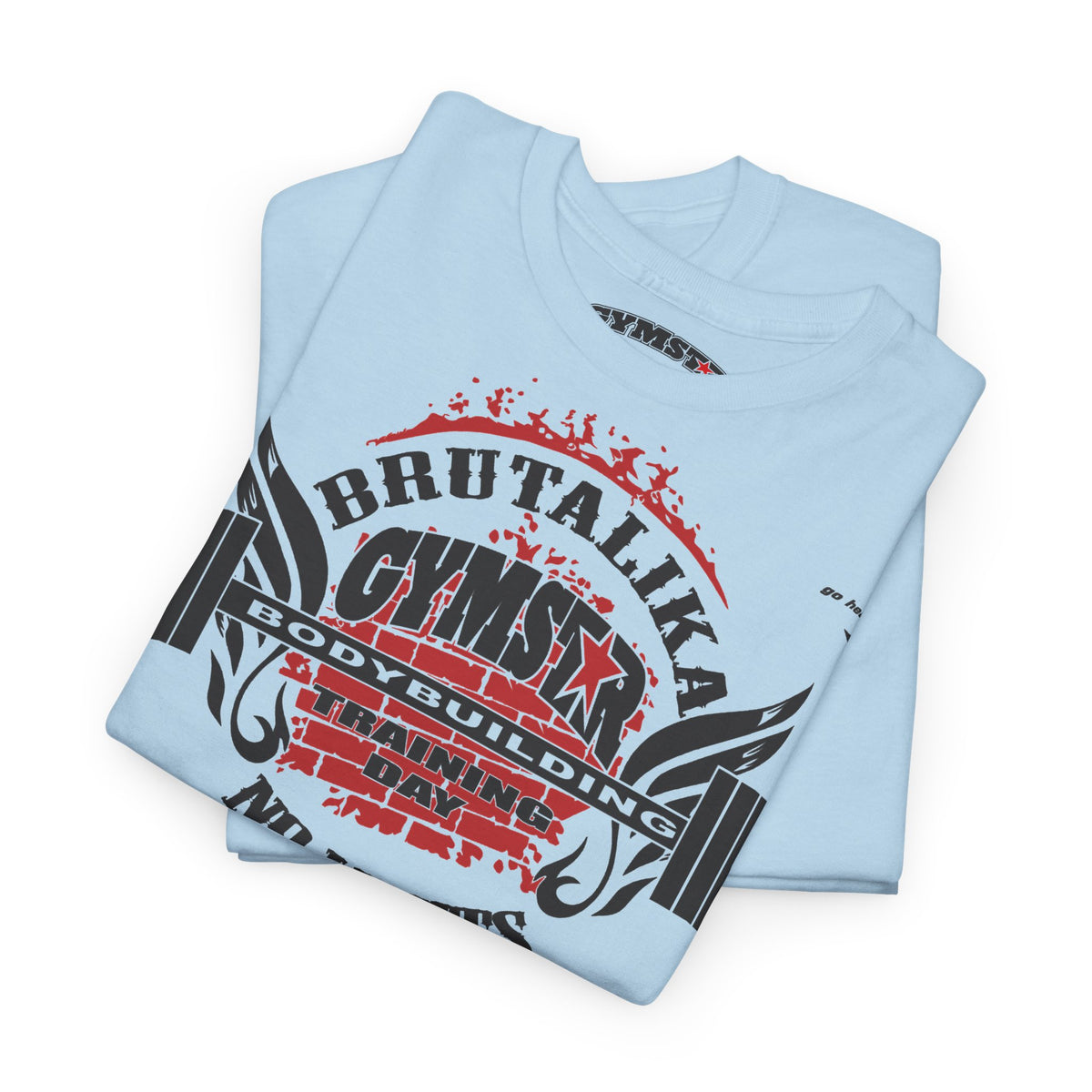 A light blue folded t-shirt with a bold graphic print on the front. The graphic features the text 'BRUTALIKA CYMSTAR BODYBUILDING TRAINING DAY' in black and red, styled with a distressed, splattered design and wing-like elements.