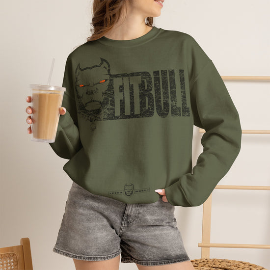 Person wearing a green sweatshirt with 'FITBULL ART' and a nebula design, holding a drink.