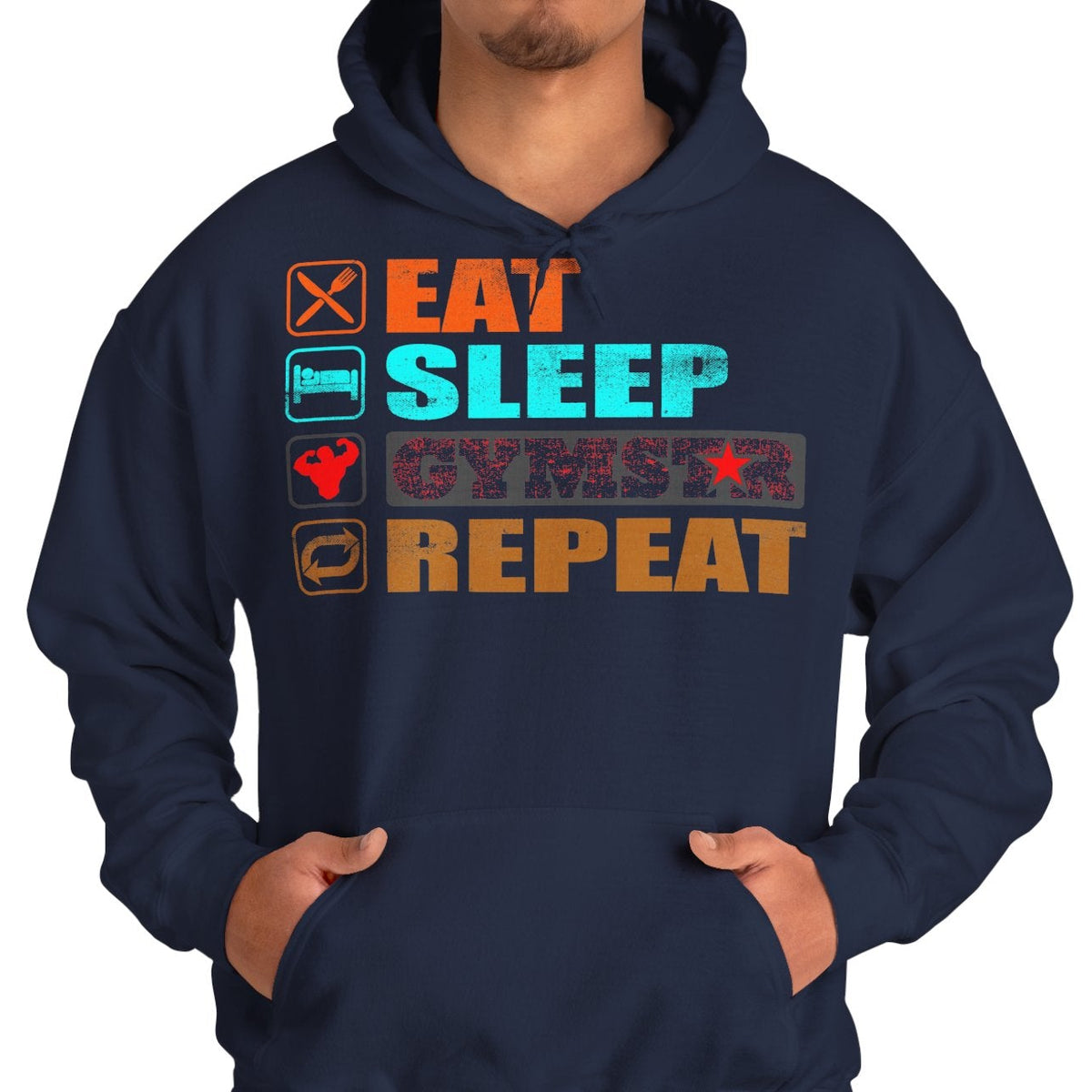 A man wearing a navy blue hoodie with a colorful graphic on the chest that reads 'EAT SLEEP GYMSTAR REPEAT' with small icons, paired with blue jeans against a plain white background.
