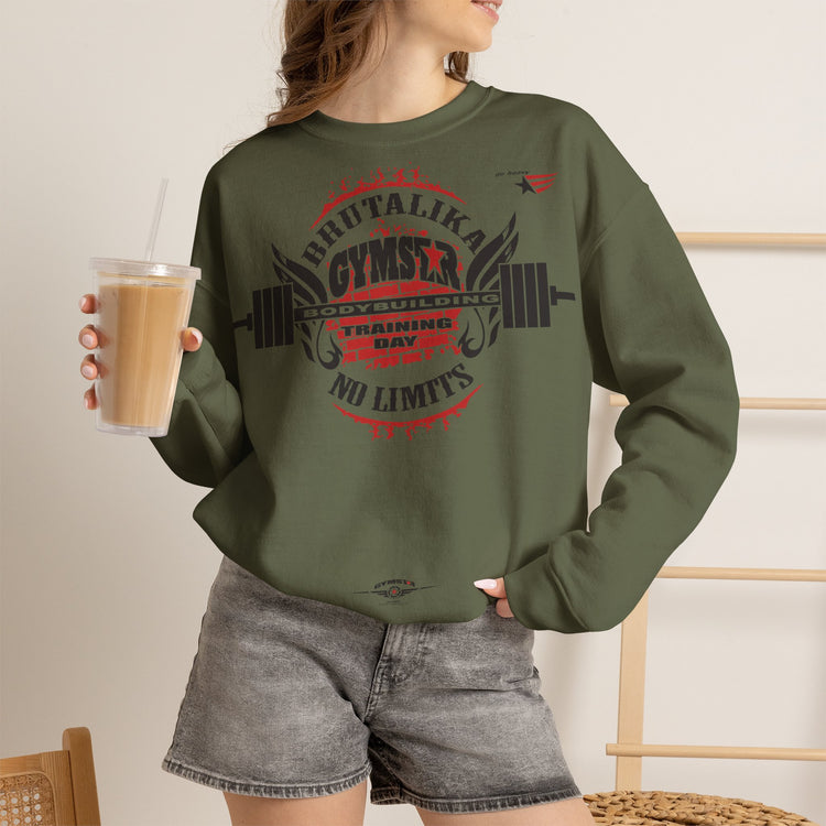 A woman wearing an olive green crewneck, fitness sweatshirt with the text 'I [red heart] GOLD WINGS' printed on the front, paired with gray denim shorts and holding an iced coffee.