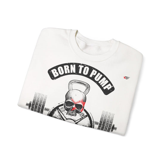 A folded white crewneck sweatshirt featuring a graphic print of a skull lifting a kettlebell with a barbell, under a black arched banner that reads 'BORN TO PUMP'. The sweatshirt is photographed on a clean white background.