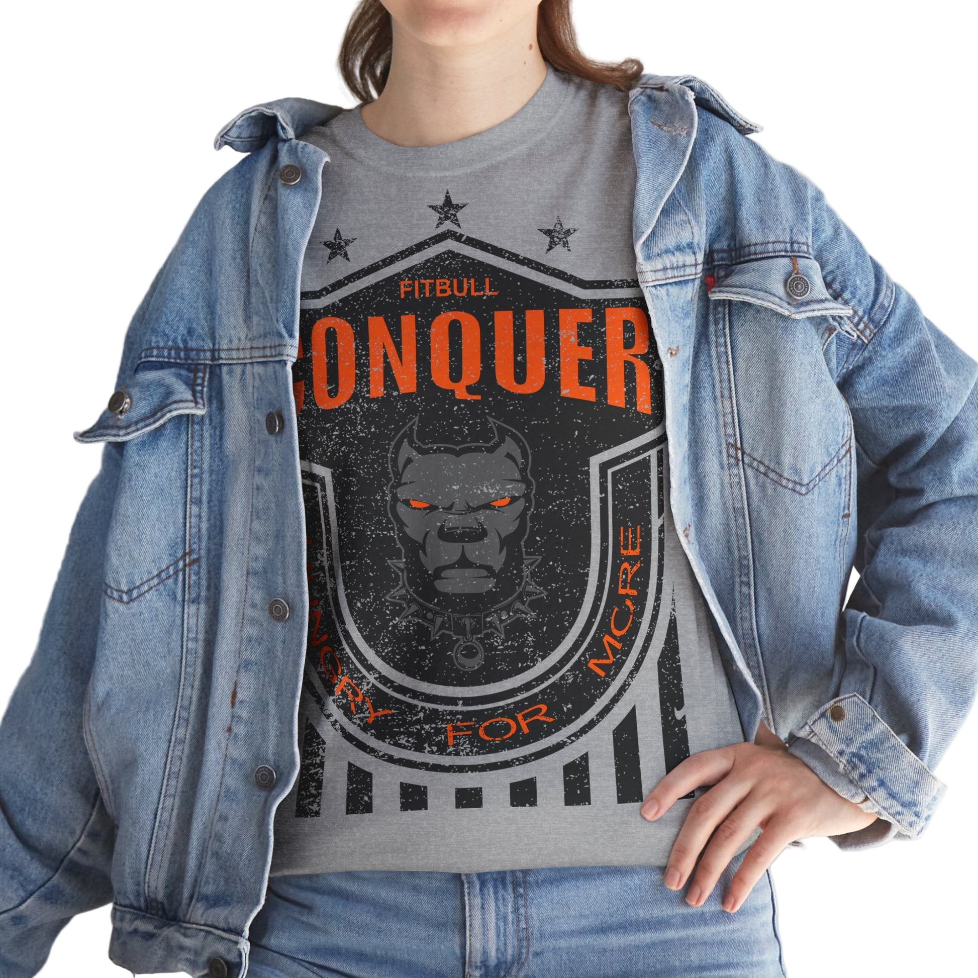 Person wearing a grayFitbull  t-shirt with a motivational Conquer graphic design and a denim jacket.